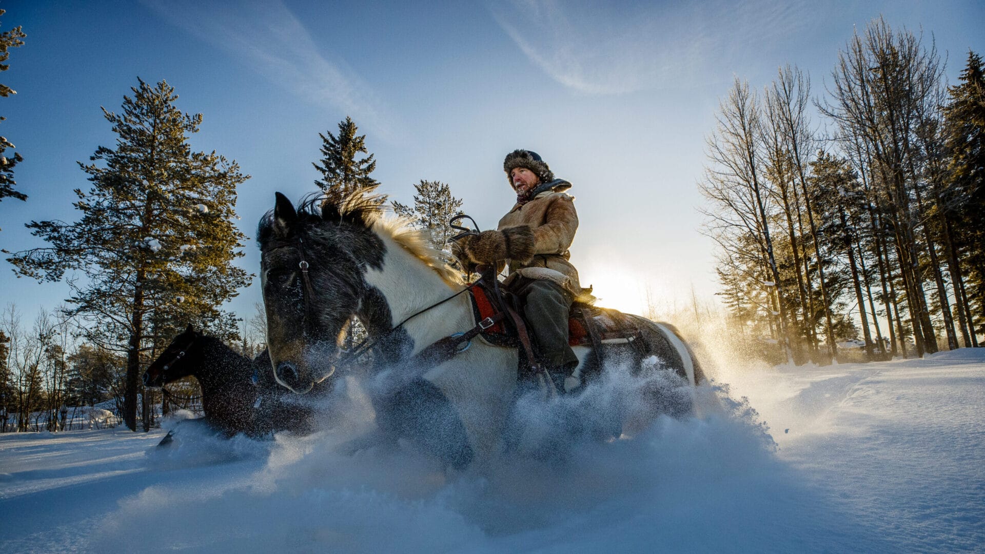 En man som rider på en häst i snön.