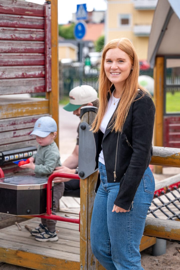 En familj med ett litet barn leker i en lekpark